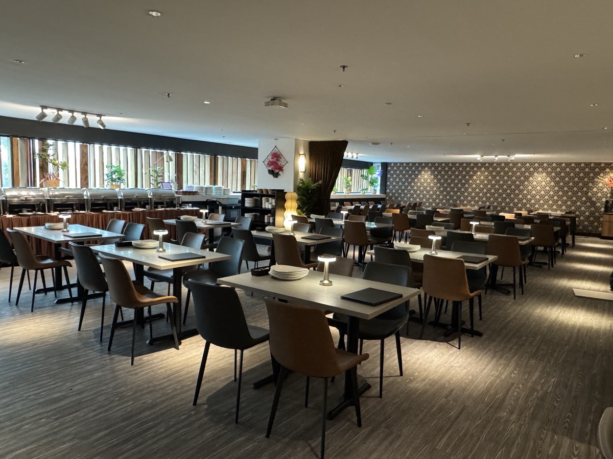 Zaffron Kitchen RELC - Premium table settings with comfortable seating arrangement and window views